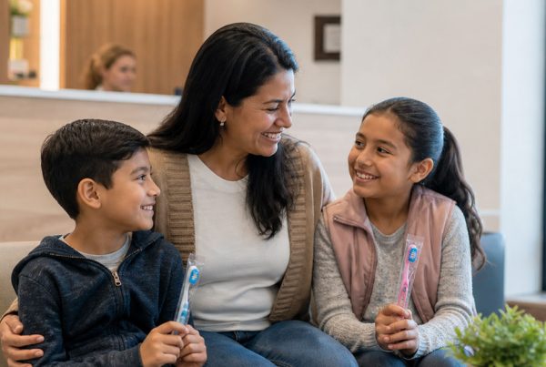 Family of three smiling together after a cavity prevention checkup at a Denville NJ dental office